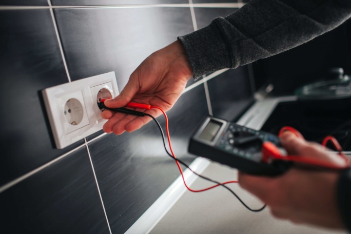 Picture of a guy testing an outlet using Circuit Tester