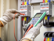 An electrical professional testing flow of current with the help of voltage tester